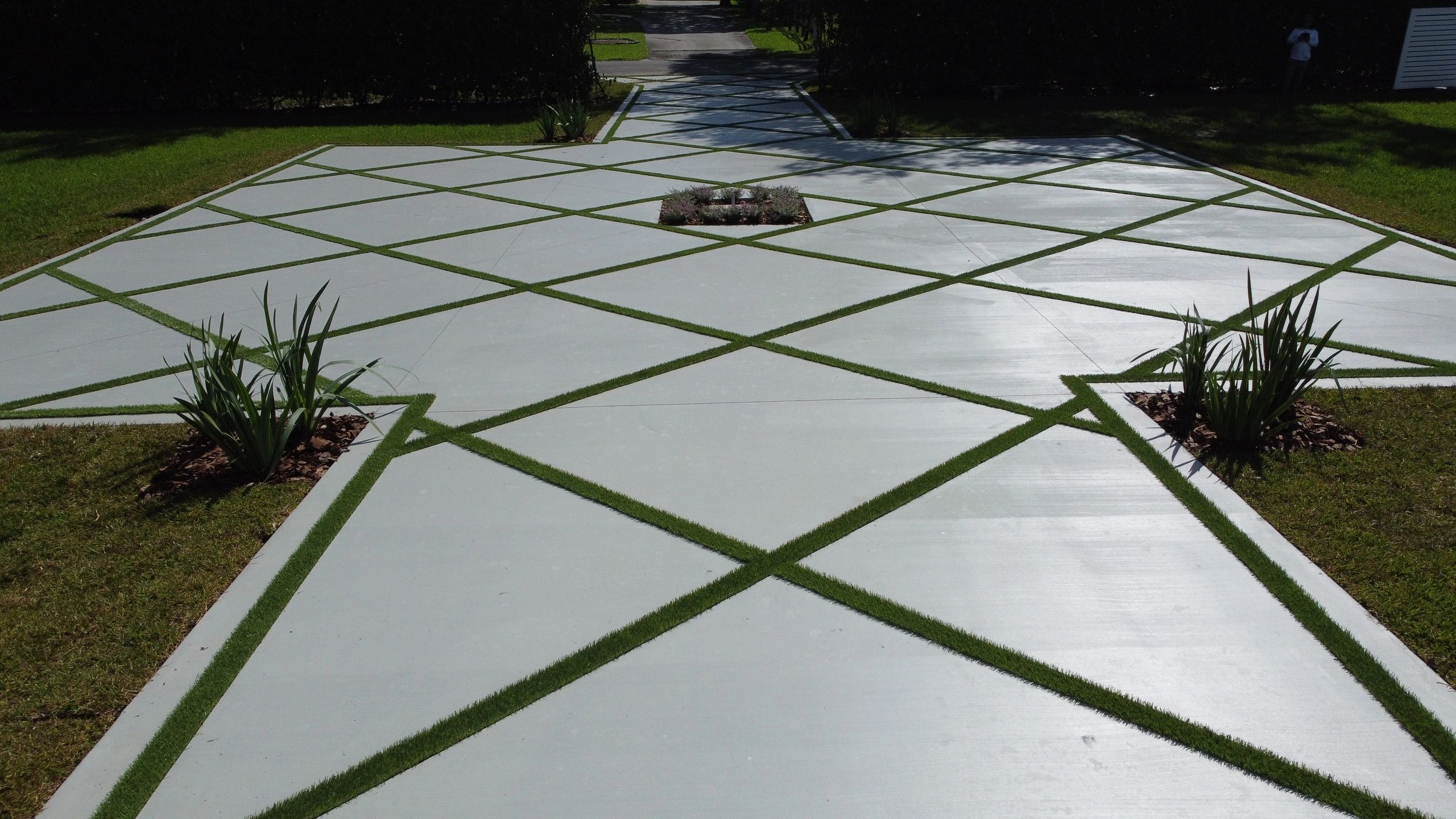 Diamond-pattern concrete and artificial grass driveway in Davie, Florida