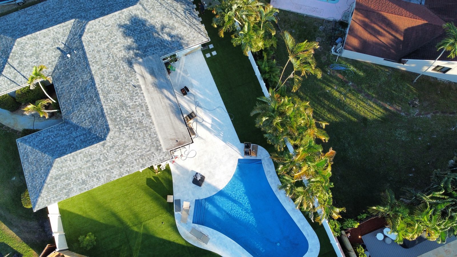 Artificial turf around a backyard pool, aerial view, Broward County, Florida