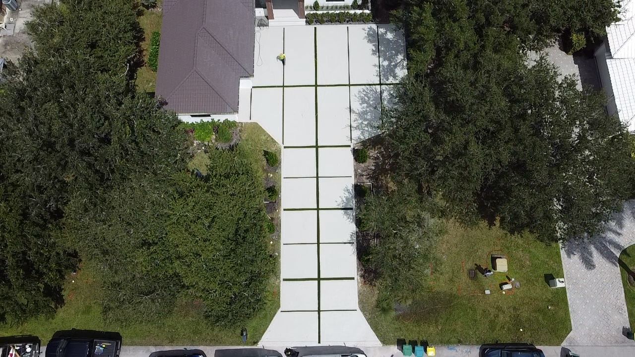 Long concrete driveway with grass joints by Concrete Solutions Today, serving Davie, FL