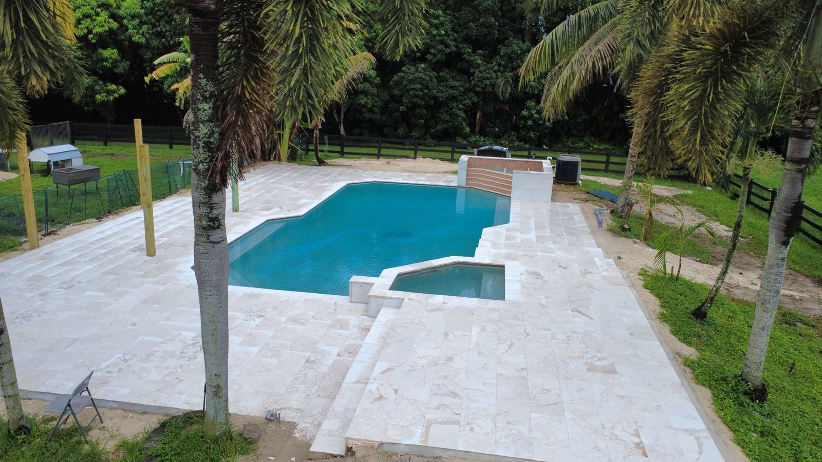 Pool and spa with a travertine-style deck by Concrete Solutions Today, serving Fort Lauderdale, FL