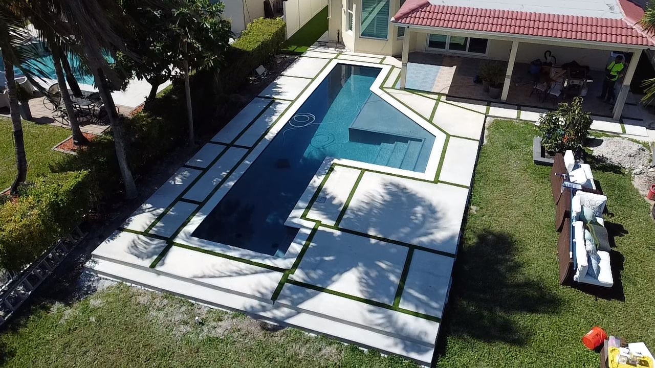 Pool deck with concrete slabs and grass joints by Concrete Solutions Today, serving Lauderdale-by-the-Sea, FL