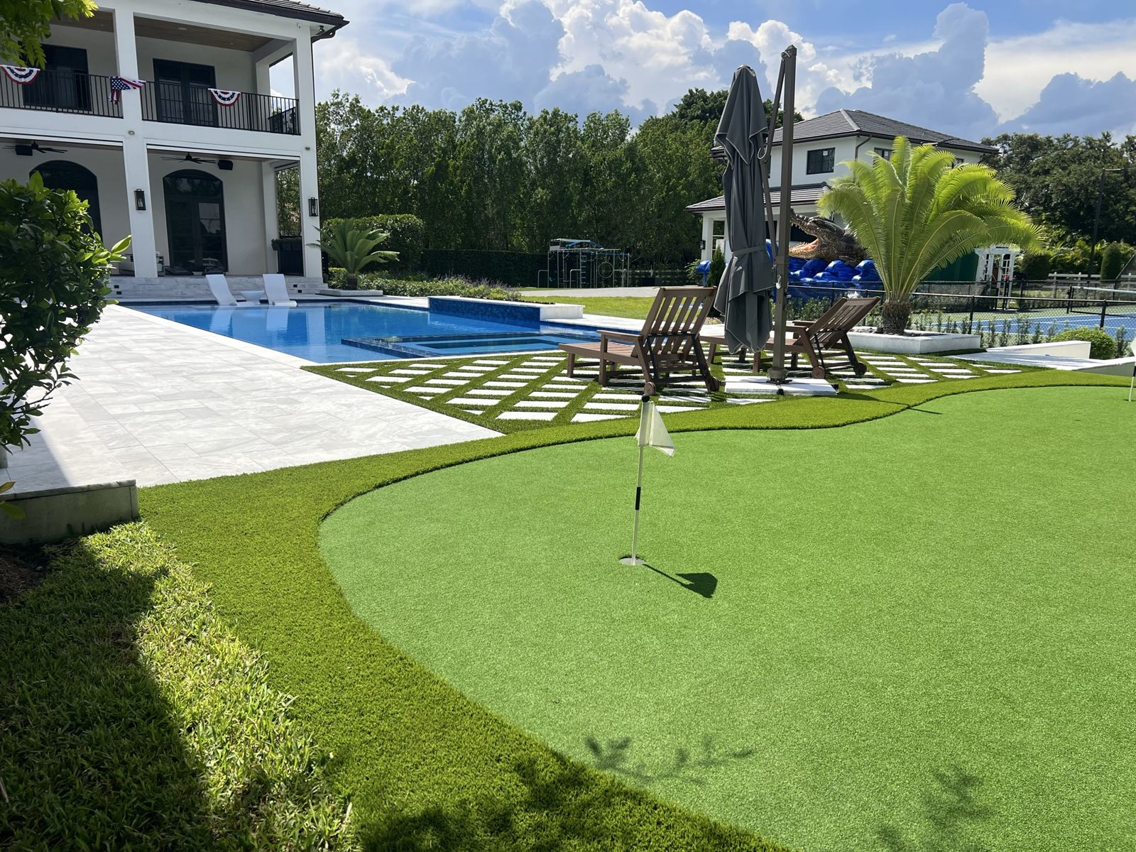 Artificial turf putting green beside the pool by Concrete Solutions Today, serving Fort Lauderdale, FL